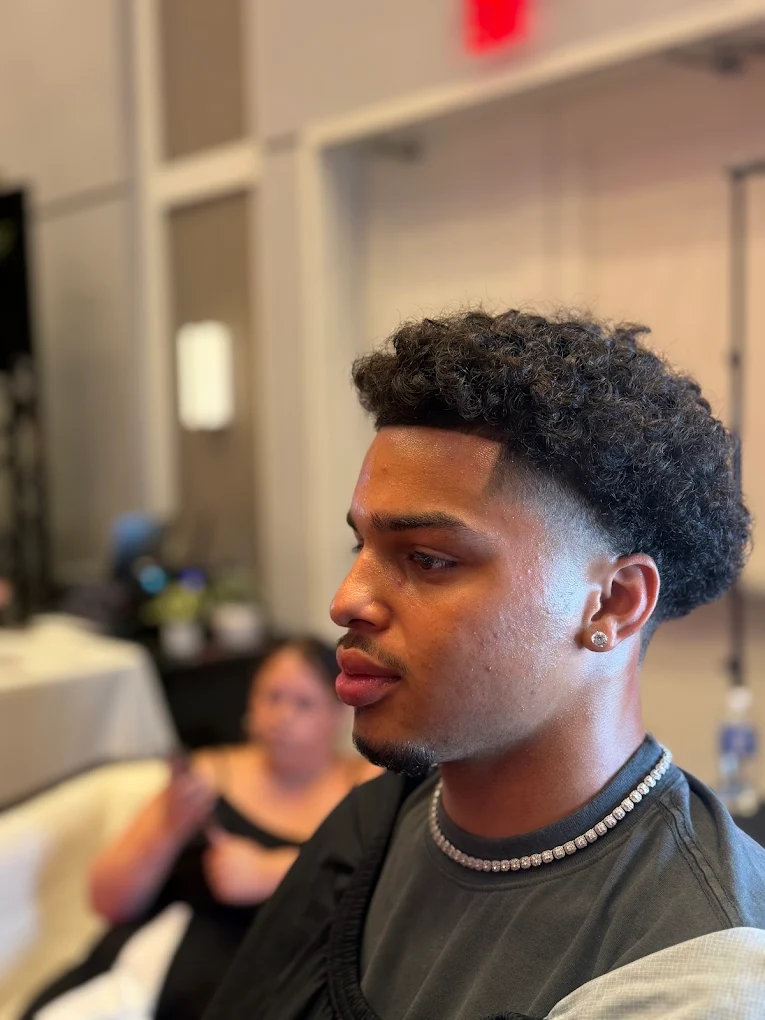 Client with a fresh taper and curly top at FadezByBoda